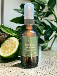 a bottle of essential oil on a counter next to a slice of lime